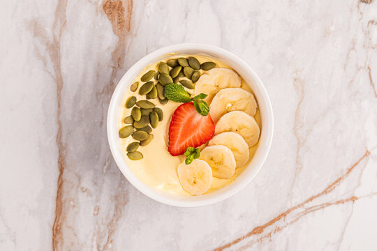 Healthy yogurt breakfast bowl with banana, strawberry, seed