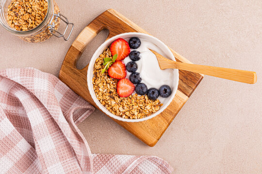 Healthy breakfast bowl with granola, yogurt, berries and nuts
