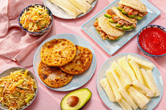 Colorful Latin American tablescape with pupusas and arepas