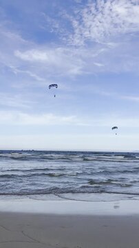 Video of a parasail flying above the sea during a water sport activity. Scenic coastal adventure representing summer vacation, travel, freedom and outdoor recreation.