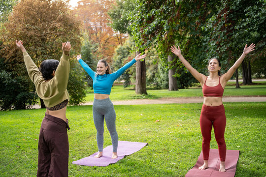 Multiethnic women practicing yoga outdoors in a park