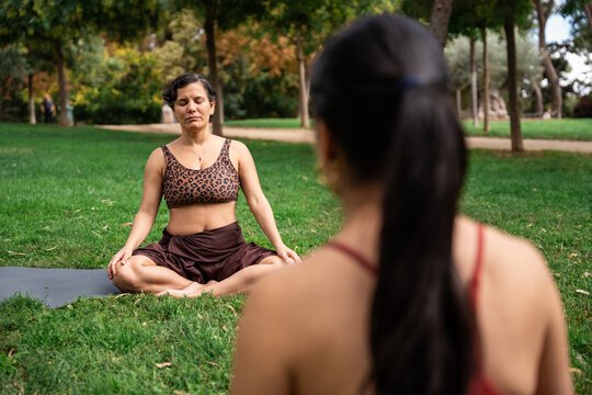 Multiethnic women practicing yoga meditation in park