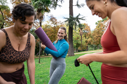 Multiethnic women preparing for outdoor yoga in park