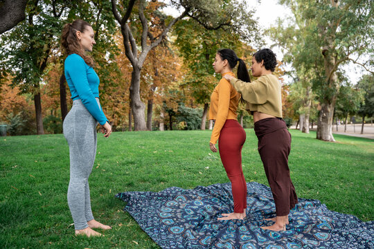 Guided yoga posture adjustment at outdoor spiritual retreat