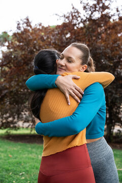 Two women hugging outdoors during a spiritual retreat break