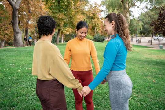 Group holding hands in park during spiritual retreat
