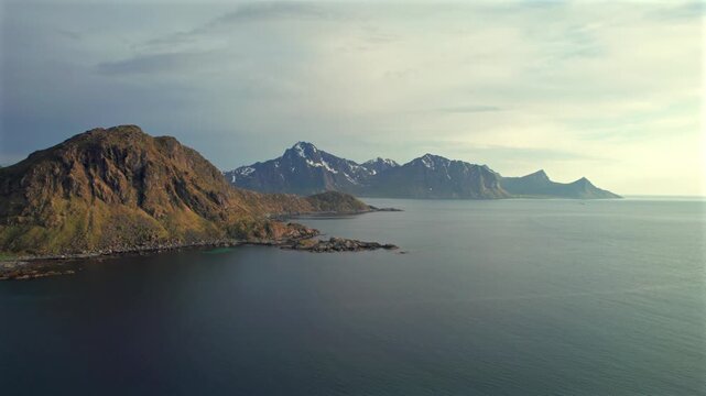 Stunning aerial perspective of Vik beach in the Lofoten Islands, showcasing the majestic snow capped mountains meeting the calm arctic sea