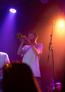 Trumpet player man performing live on stage with bright lights
