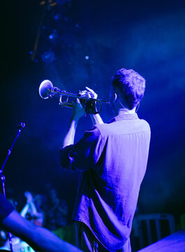 Trumpet player man performing live on stage in blue spotlight