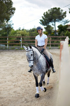 Woman riding horse in equestrian training session