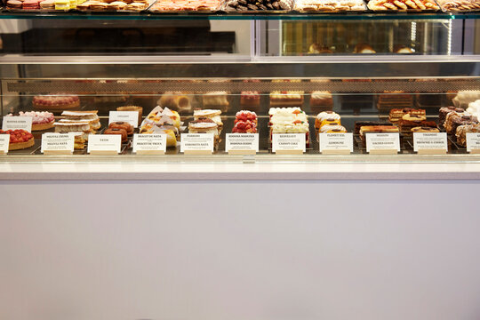 Pastry and cake display case with labels in bakery