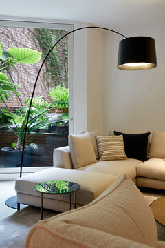 Modern living room with sofa, arc lamp, and patio view