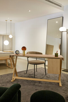 Minimal home office interior with desk, mirror and lighting