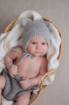 Adorable infant in cozy knitwear resting in basket