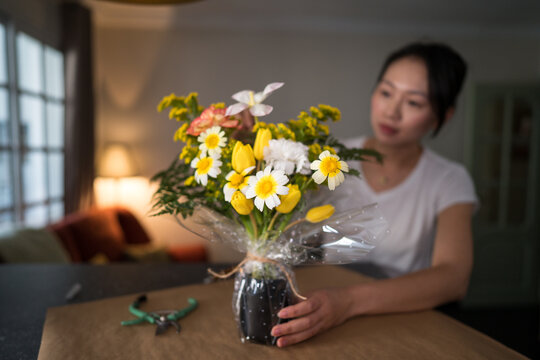 Woman arranging fresh flowers at home as a creative hobby