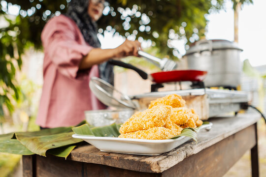 Muslim Indonesian woman cooking traditional street food outdoors