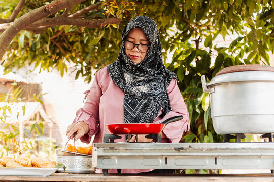 Muslim Indonesian woman cooking traditional street food