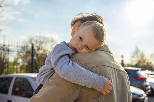 Father holding toddler in warm embrace outdoors on father&rsquo;s day
