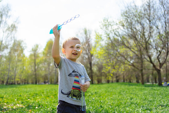 Toddler playing with bubble wand in sunny spring park