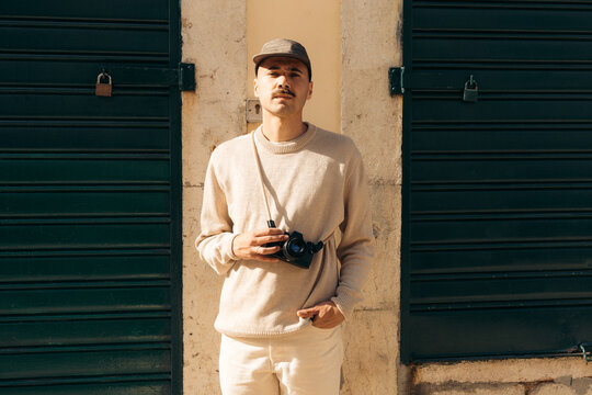 Urban lifestyle portrait of male photographer with camera