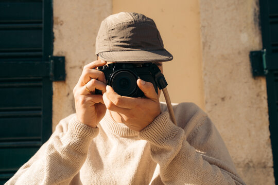 Lifestyle photographer man taking photo outdoors in sunlight