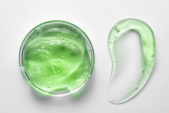 Green cosmetic gel in container with a smooth smear