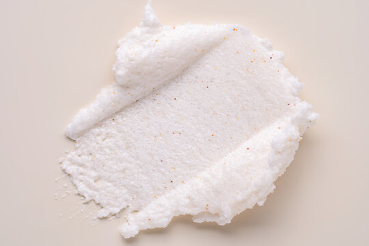 Body scrub smear texture on beige background, cosmetic