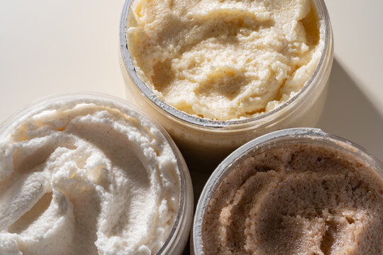 Creamy body scrub texture smeared in open cosmetic jar
