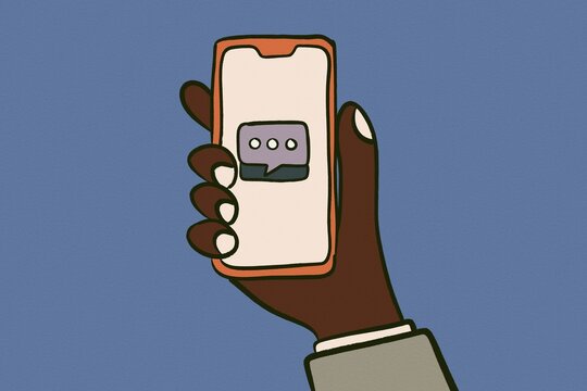 Hand holding smartphone showing chat icon for mobile messaging