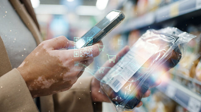 Close-up of a person with vitiligo using a smartphone to scan a QR code for product information in a supermarket with a graphic overlay with shopping cart icons, smart retail concept
