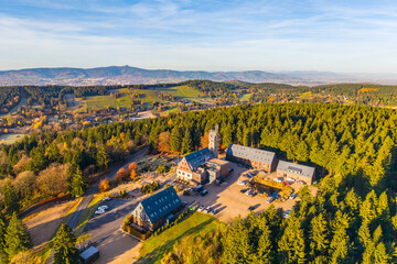Fototapeta premium Kralovka Lookout Tower offers breathtaking views of the Jizera Mountains. Nestled in vibrant autumn colors, it invites visitors to enjoy nature's beauty and tranquility.
