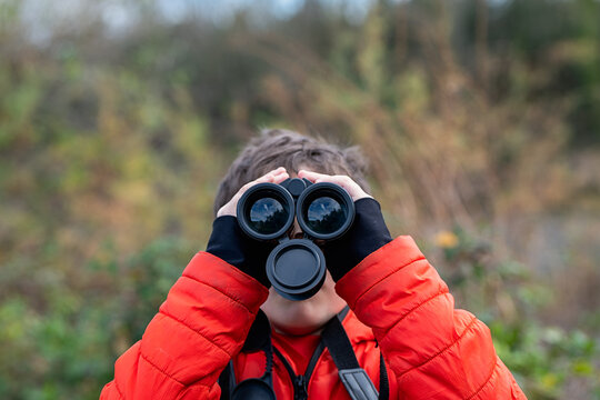 Child exploring nature through binoculars