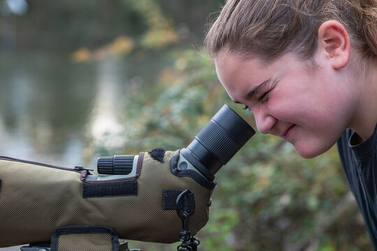 Young nature enthusiast observing through a spotting scope