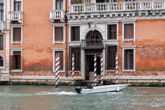 Venice canal facade with balcony and mooring pole view