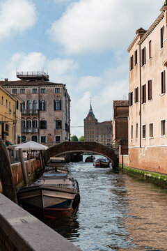 Venice canal with bridge, boats and pastel building facade