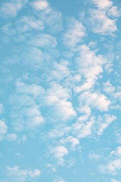 Soft blue sky with scattered white cloud background