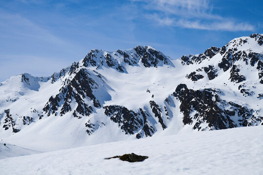 Snow covered mountain ridge in Andorra under blue sky