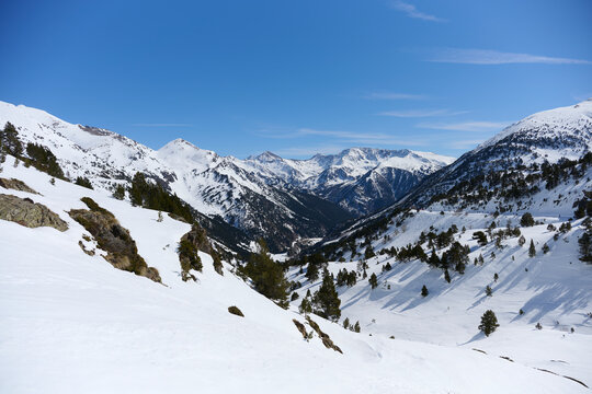 Snowy mountain valley panorama under clear blue sky, Andorra
