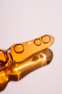 Amber glass beauty ampule with cosmetic serum macro shot