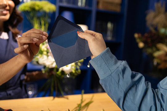Blue envelope exchange at a flower shop counter