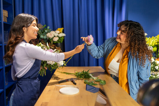 Cheerful interaction at a local flower shop counter