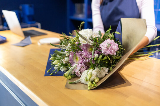 Florist crafting bouquet in a blue-themed flower shop