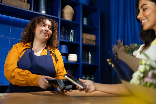 Florist assisting customer in blue-themed shop