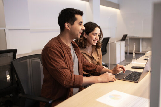Coworking team collaborating on laptop in modern office