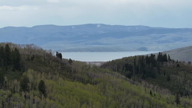 Aerial view of Strawberry Reservoir through Uinta mountains in Utah in spring with cloudy sky