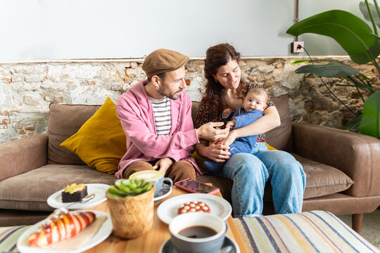 New mom and dad cuddling newborn in cozy home moment