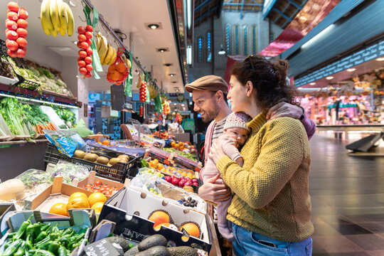 Happy family with newborn shopping at indoor market