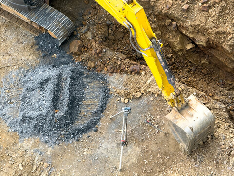 Excavator at construction site with gravel and soil