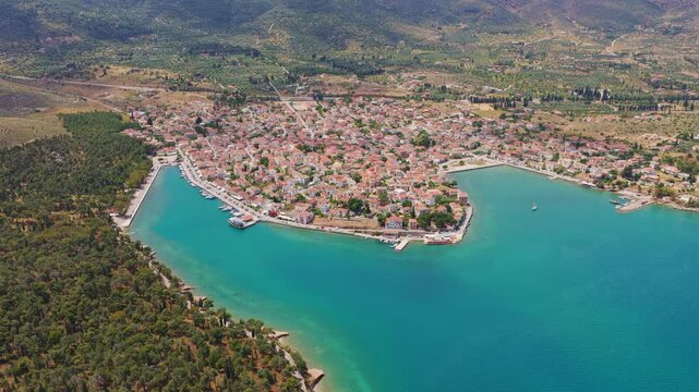 Beautiful aerial perspective of Galaxidi, a picturesque coastal town in Greece, showcasing the peninsula with traditional red-roofed houses surrounded by the stunning turquoise aegean sea