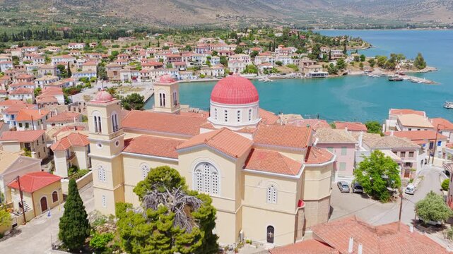Sunny aerial view of the picturesque seaside town of galaxidi, fokida, showing its historic red-tiled roof buildings and turquoise bay waters on the coast of the gulf of corinth in greece